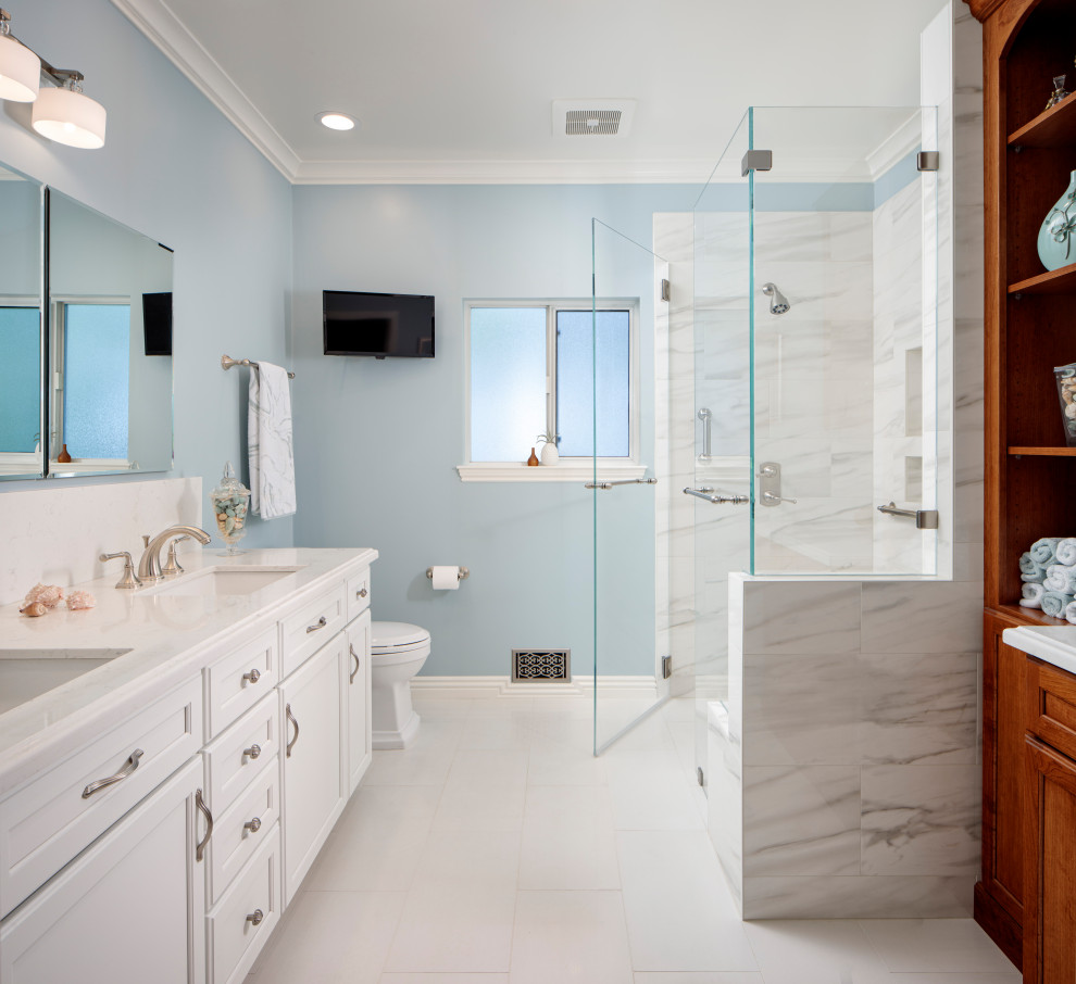 Example of a mid-sized transitional master ceramic tile and white floor walk-in shower design in San Francisco with recessed-panel cabinets, white cabinets, blue walls, an undermount sink, quartz countertops, a hinged shower door and white countertops