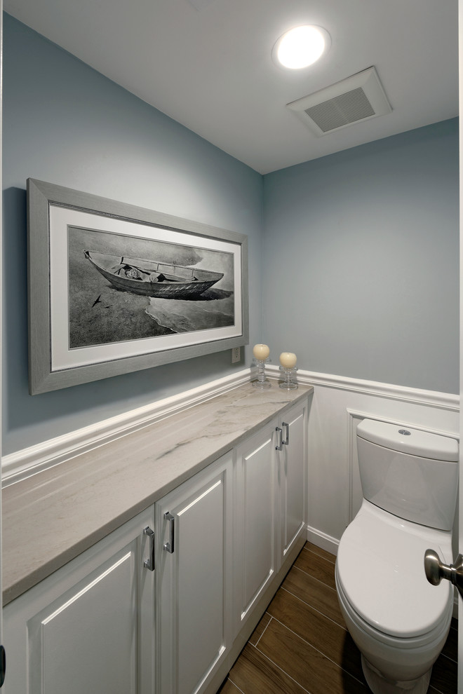 Exempel på ett stort modernt toalett, med luckor med upphöjd panel, vita skåp, en toalettstol med separat cisternkåpa, blå väggar, mosaikgolv, marmorbänkskiva och ett undermonterad handfat