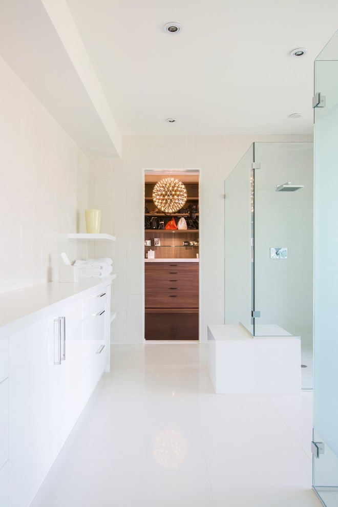 Modelo de cuarto de baño actual con armarios con paneles lisos, puertas de armario blancas, ducha esquinera y paredes blancas
