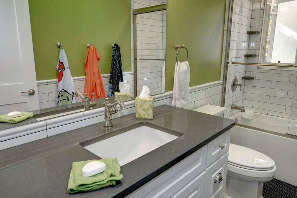 Foto på ett mellanstort eklektiskt badrum med dusch, med luckor med upphöjd panel, vita skåp, ett fristående badkar, en dusch/badkar-kombination, en toalettstol med separat cisternkåpa, vit kakel, tunnelbanekakel, gröna väggar, mosaikgolv, ett undermonterad handfat och bänkskiva i akrylsten