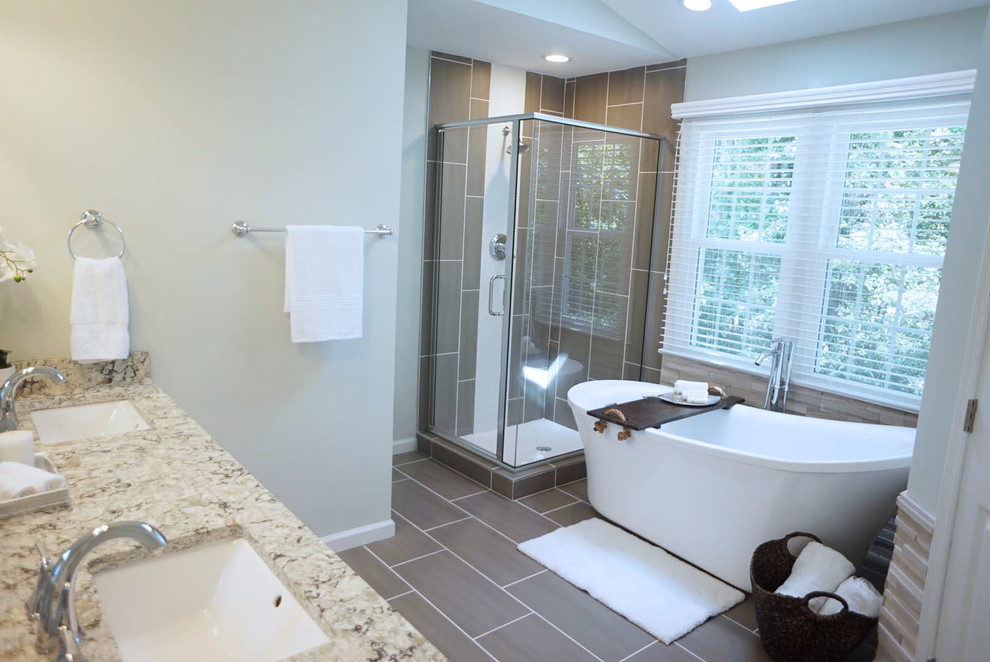 Пример оригинального дизайна: главная ванная комната среднего размера в стиле неоклассика (современная классика) с отдельно стоящей ванной, угловым душем, серой плиткой, синими стенами и врезной раковиной
