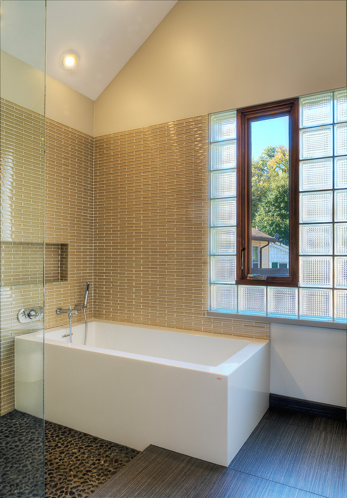 Idee per una stanza da bagno design con vasca freestanding, piastrelle marroni e pavimento con piastrelle di ciottoli