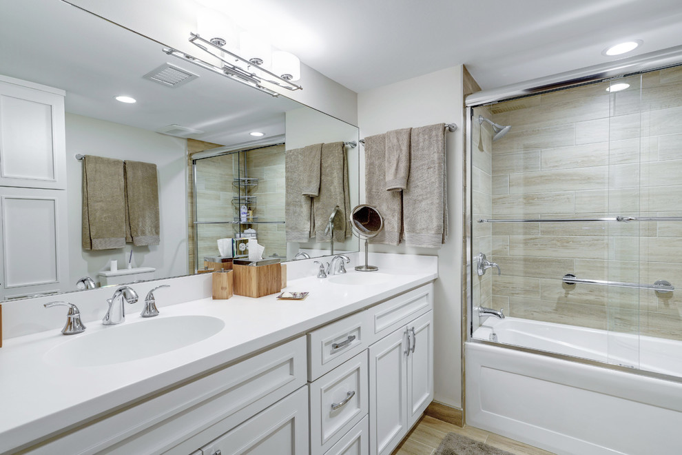 Пример оригинального дизайна: главная ванная комната среднего размера в классическом стиле с фасадами в стиле шейкер, белыми фасадами, душем над ванной, раздельным унитазом, бежевой плиткой, белыми стенами, полом из керамогранита, бежевым полом, душем с раздвижными дверями, белой столешницей, ванной в нише, керамогранитной плиткой и монолитной раковиной