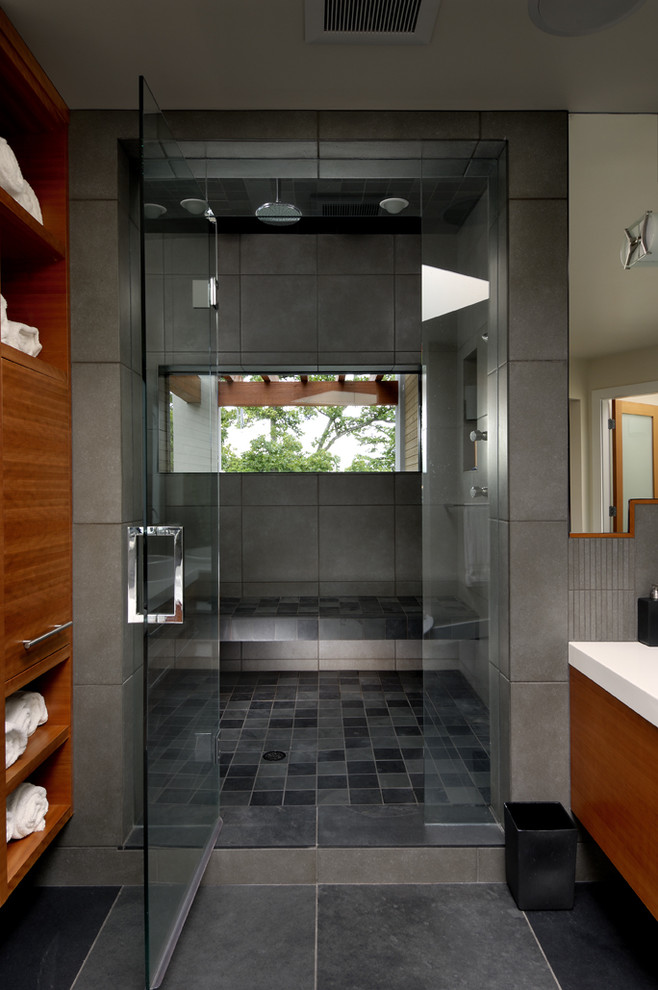This is an example of a contemporary bathroom in Vancouver with medium wood cabinets, an alcove shower and black tiles.