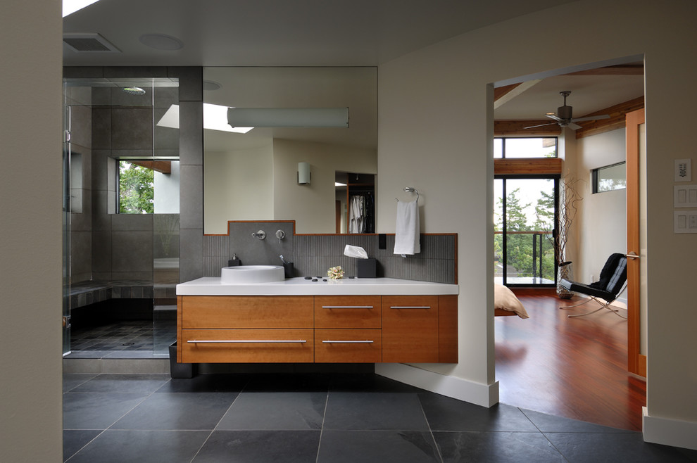 Modernes Badezimmer mit Aufsatzwaschbecken, flächenbündigen Schrankfronten, hellbraunen Holzschränken, Duschnische und schwarzen Fliesen in Vancouver
