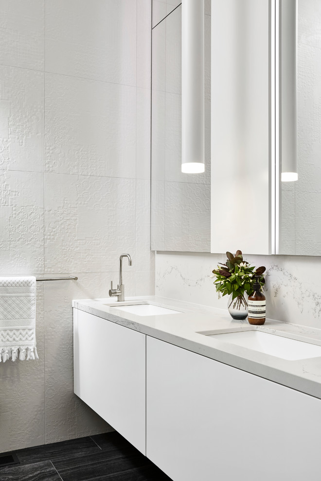На фото: серо-белая ванная комната в современном стиле с плоскими фасадами, белыми фасадами, серыми стенами и врезной раковиной