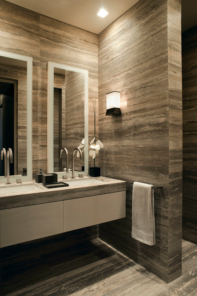 Exemple d'une salle de bain tendance avec un placard à porte plane, des portes de placard blanches, un lavabo encastré et un mur en pierre.