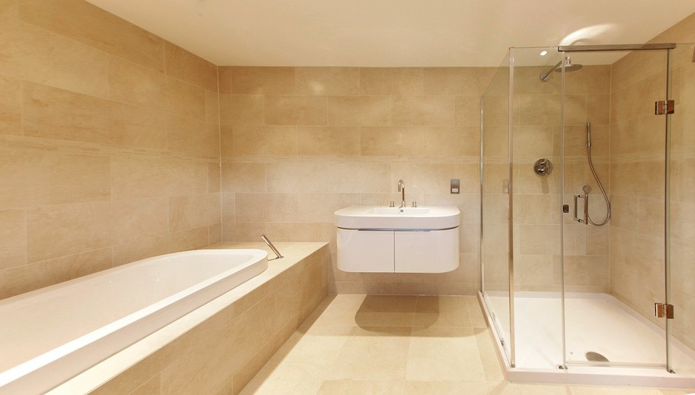 Cette image montre une grande salle de bain principale design avec un plan vasque, une baignoire posée, une douche double, un carrelage beige, des dalles de pierre, un mur beige et un sol en travertin.