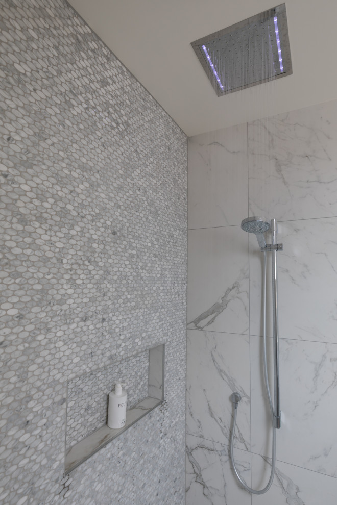 Modern inredning av ett litet grå grått badrum, med släta luckor, grå skåp, svart kakel, porslinskakel, klinkergolv i porslin, ett fristående handfat, bänkskiva i kvarts och svart golv