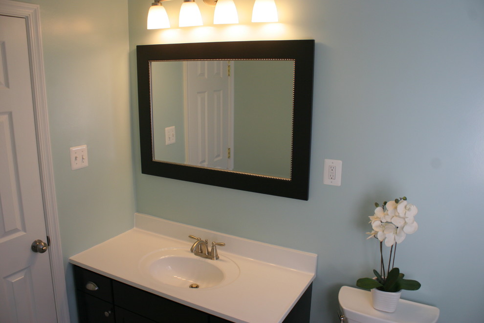 Стильный дизайн: ванная комната среднего размера в стиле модернизм с монолитной раковиной, фасадами в стиле шейкер, темными деревянными фасадами, столешницей из искусственного камня, ванной в нише, раздельным унитазом, серой плиткой, керамической плиткой, синими стенами, полом из керамической плитки и душевой кабиной - последний тренд