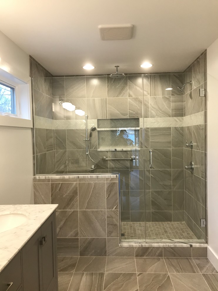 Bild på ett mellanstort vintage badrum med dusch, med skåp i shakerstil, bruna skåp, en dusch i en alkov, grå kakel, keramikplattor, vita väggar, klinkergolv i keramik, ett undermonterad handfat, granitbänkskiva, grått golv och dusch med gångjärnsdörr
