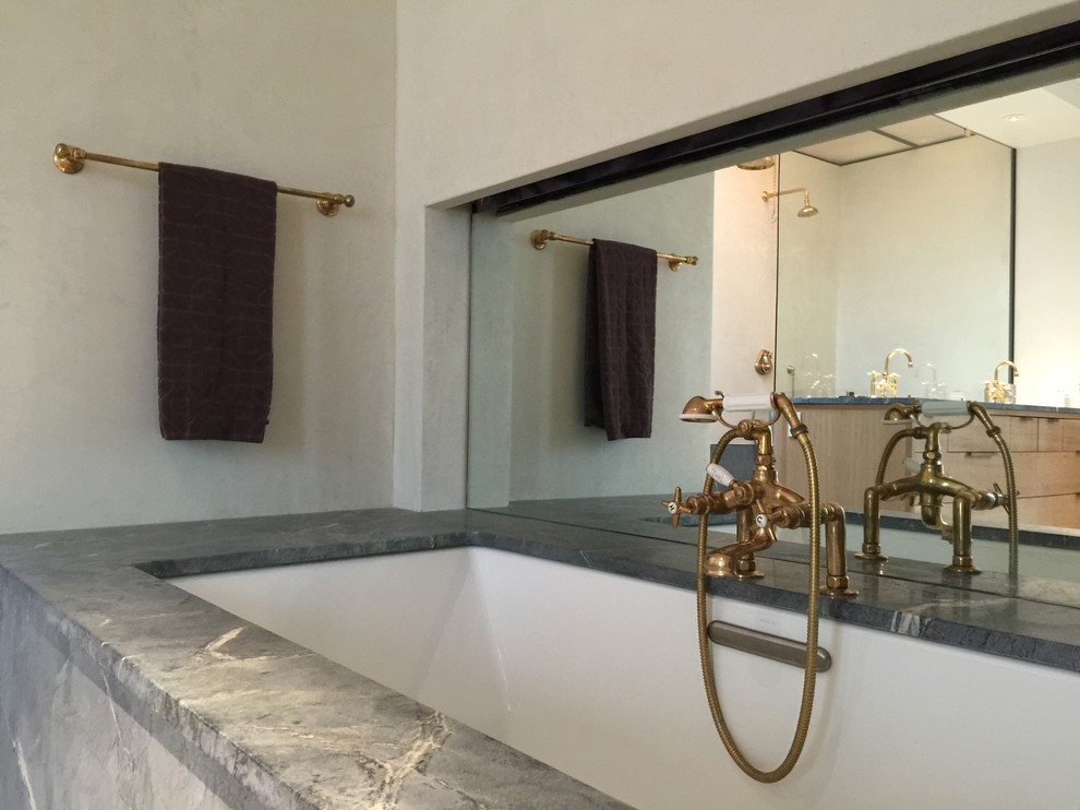 Идея дизайна: большая главная ванная комната в стиле модернизм с плоскими фасадами, светлыми деревянными фасадами, унитазом-моноблоком, бежевыми стенами, бетонным полом, раковиной с несколькими смесителями и столешницей из искусственного камня