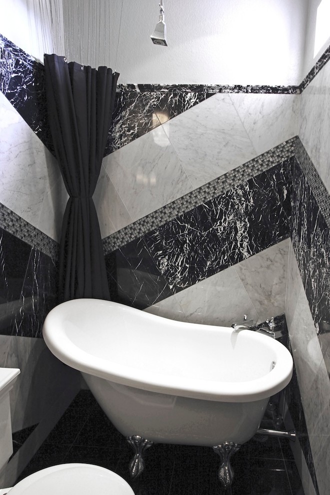 Bild på ett mellanstort funkis badrum, med en toalettstol med separat cisternkåpa, svart och vit kakel, marmorkakel, vita väggar, ett fristående handfat, marmorbänkskiva, svart golv, ett badkar med tassar, en dusch/badkar-kombination och dusch med duschdraperi