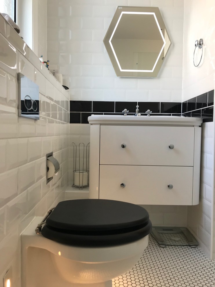 Bathroom - mid-sized contemporary kids' ceramic tile mosaic tile floor and white floor bathroom idea in London with furniture-like cabinets, white cabinets, a one-piece toilet, white walls and a wall-mount sink