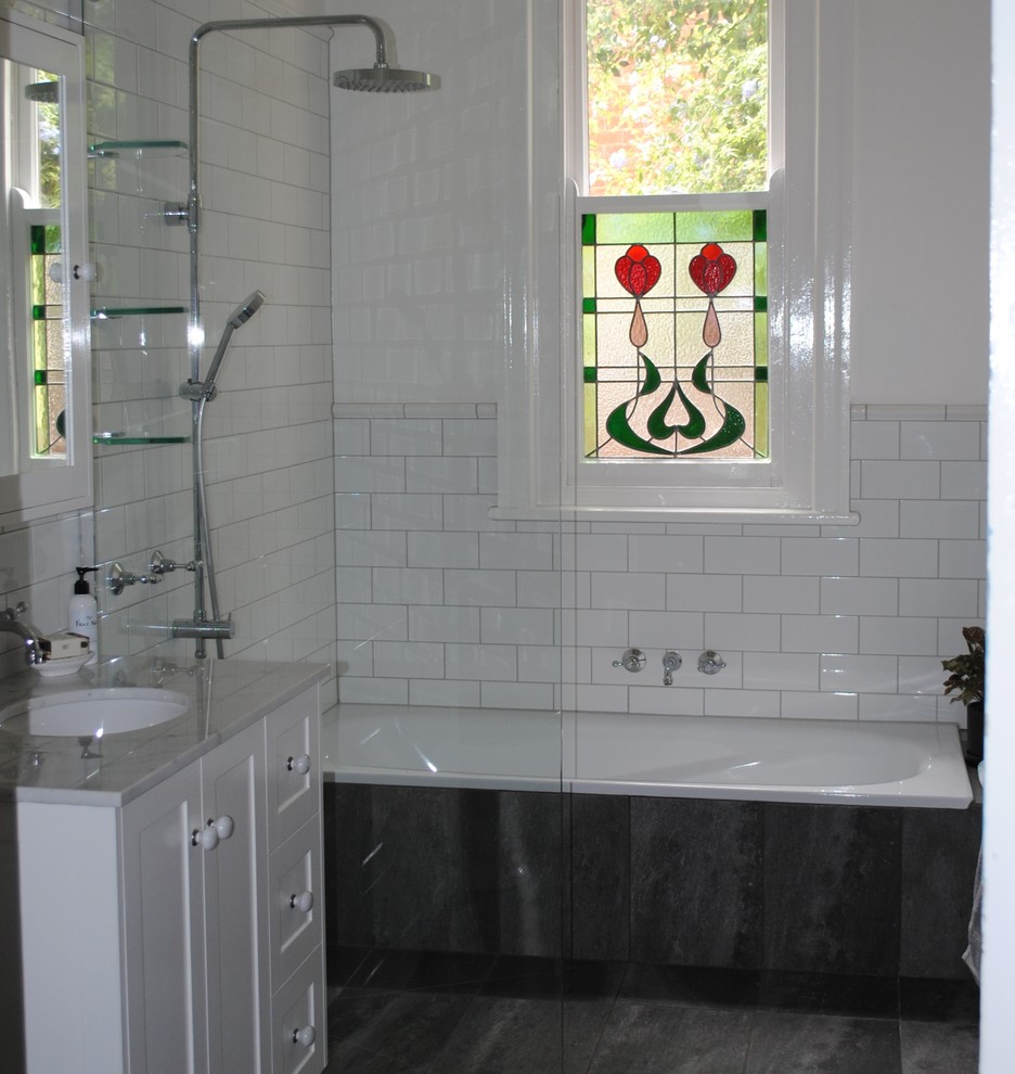 Inspiration for a small victorian ensuite bathroom in Other with recessed-panel cabinets, white cabinets, a built-in bath, a walk-in shower, a two-piece toilet, white tiles, ceramic tiles, white walls, porcelain flooring, a submerged sink, marble worktops, grey floors and an open shower.