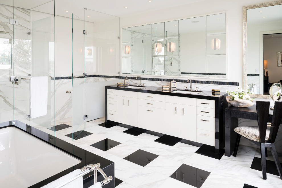 Inspiration for a large traditional ensuite wet room bathroom in Melbourne with white tiles, marble tiles, a submerged sink, granite worktops, a hinged door, recessed-panel cabinets, white cabinets, a built-in bath, white walls, multi-coloured floors and black worktops.
