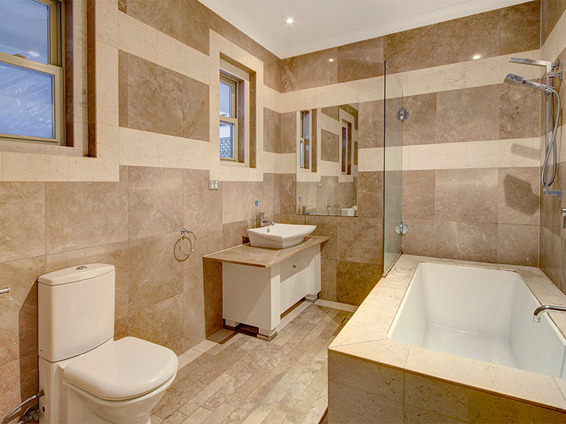 Idéer för ett mellanstort klassiskt badrum med dusch, med ett hörnbadkar, en hörndusch, flerfärgade väggar, marmorgolv, bänkskiva i kalksten, brunt golv och kakelplattor