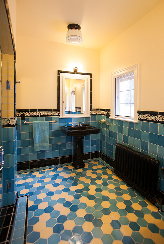 Inredning av ett stort en-suite badrum, med en dubbeldusch, en toalettstol med separat cisternkåpa, blå kakel, porslinskakel, gula väggar, klinkergolv i porslin och ett piedestal handfat