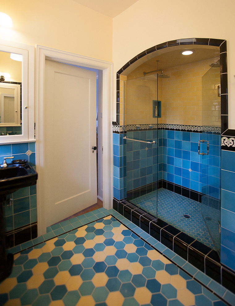 Inredning av ett stort en-suite badrum, med en dubbeldusch, en toalettstol med separat cisternkåpa, blå kakel, porslinskakel, gula väggar, klinkergolv i porslin och ett piedestal handfat