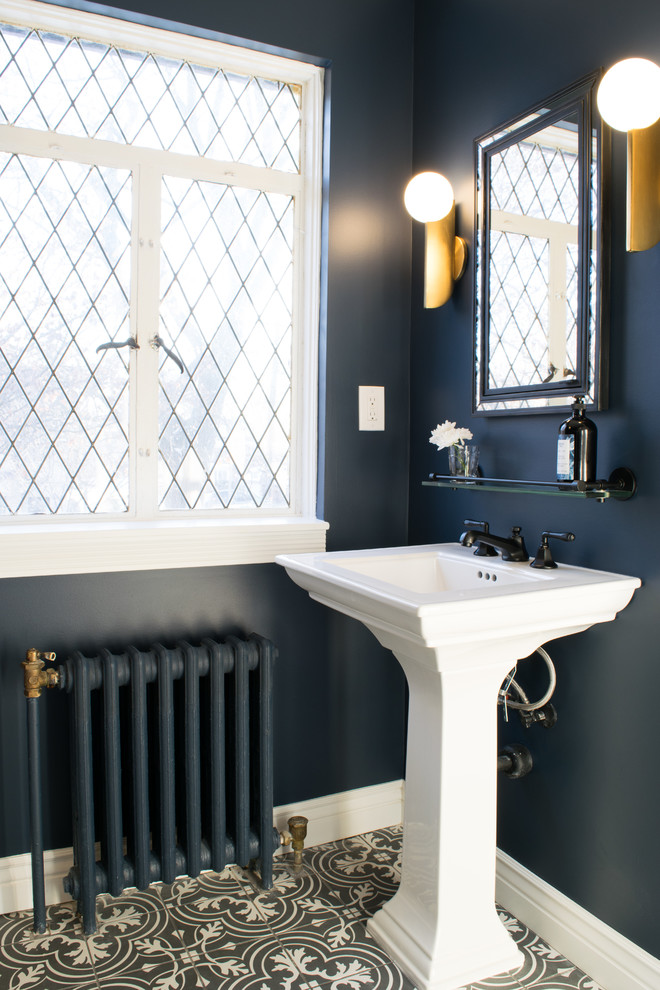 Photo of a medium sized modern ensuite bathroom in Detroit with a claw-foot bath, a one-piece toilet, blue walls, ceramic flooring, a pedestal sink, black floors and a hinged door.