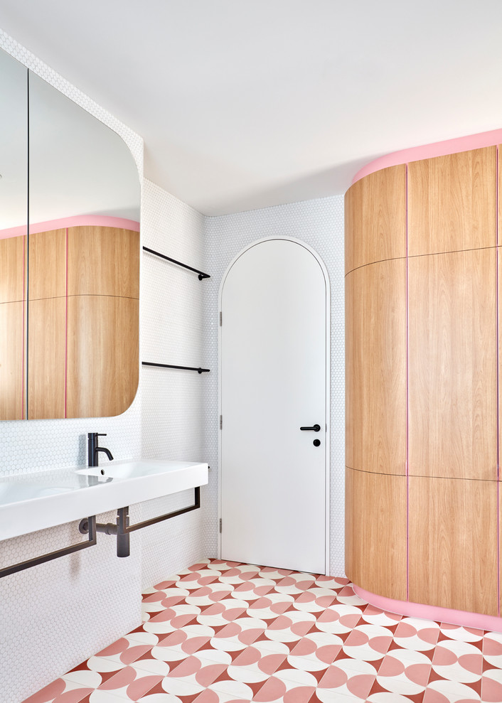 Idéer för ett litet minimalistiskt en-suite badrum, med ett fristående badkar, en hörndusch, en toalettstol med hel cisternkåpa, vit kakel, mosaik, vita väggar, cementgolv, ett väggmonterat handfat, rosa golv och dusch med gångjärnsdörr