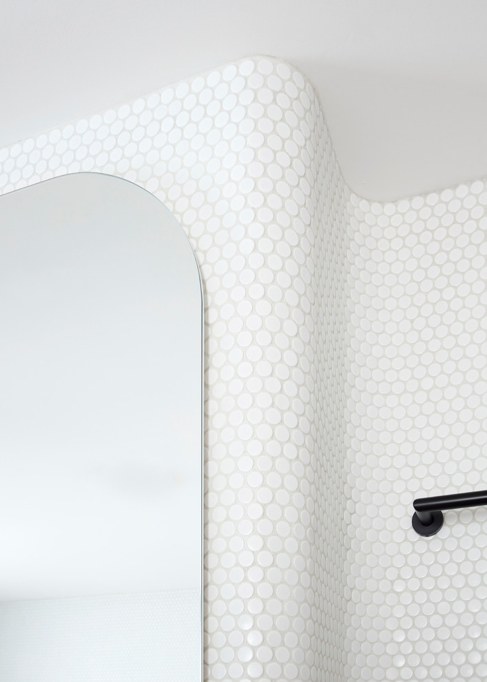 Inredning av ett skandinaviskt litet en-suite badrum, med ett fristående badkar, en hörndusch, en toalettstol med hel cisternkåpa, vit kakel, mosaik, vita väggar, cementgolv, ett väggmonterat handfat, rosa golv och dusch med gångjärnsdörr
