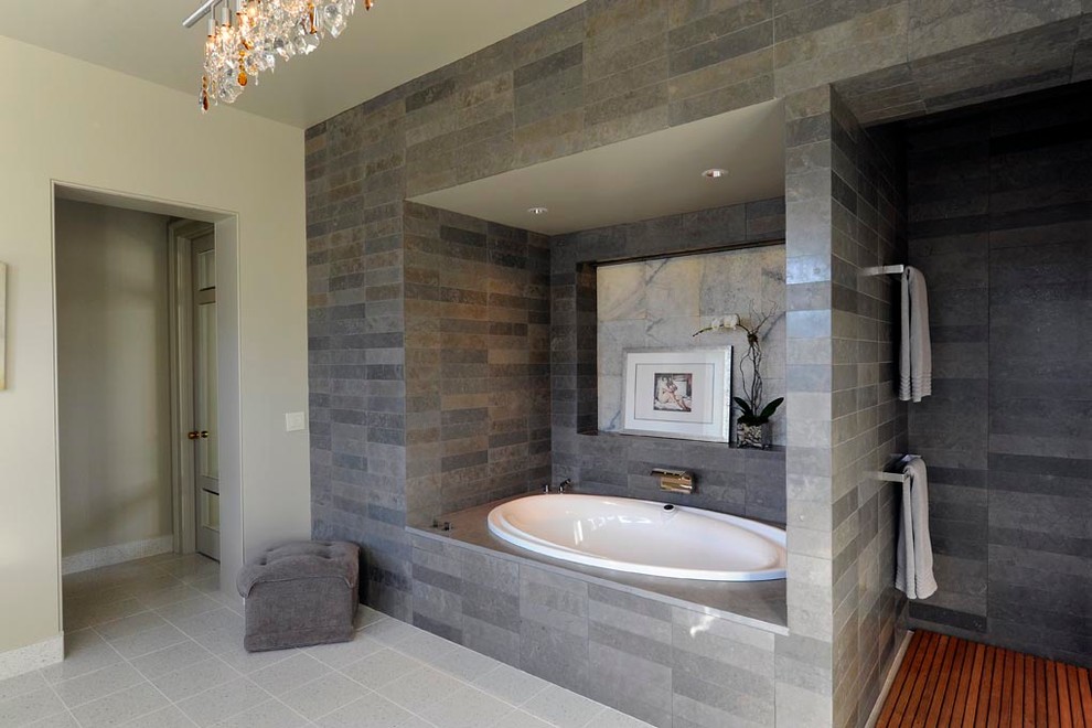 This is an example of a classic ensuite bathroom in Nashville with freestanding cabinets, medium wood cabinets, an alcove bath, a built-in shower, a two-piece toilet, grey tiles, porcelain tiles, grey walls, porcelain flooring, a vessel sink and marble worktops.