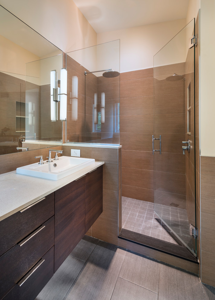 Inspiration for a mid-sized contemporary master brown tile and ceramic tile ceramic tile alcove shower remodel in Boston with flat-panel cabinets, dark wood cabinets, white walls, a drop-in sink and solid surface countertops
