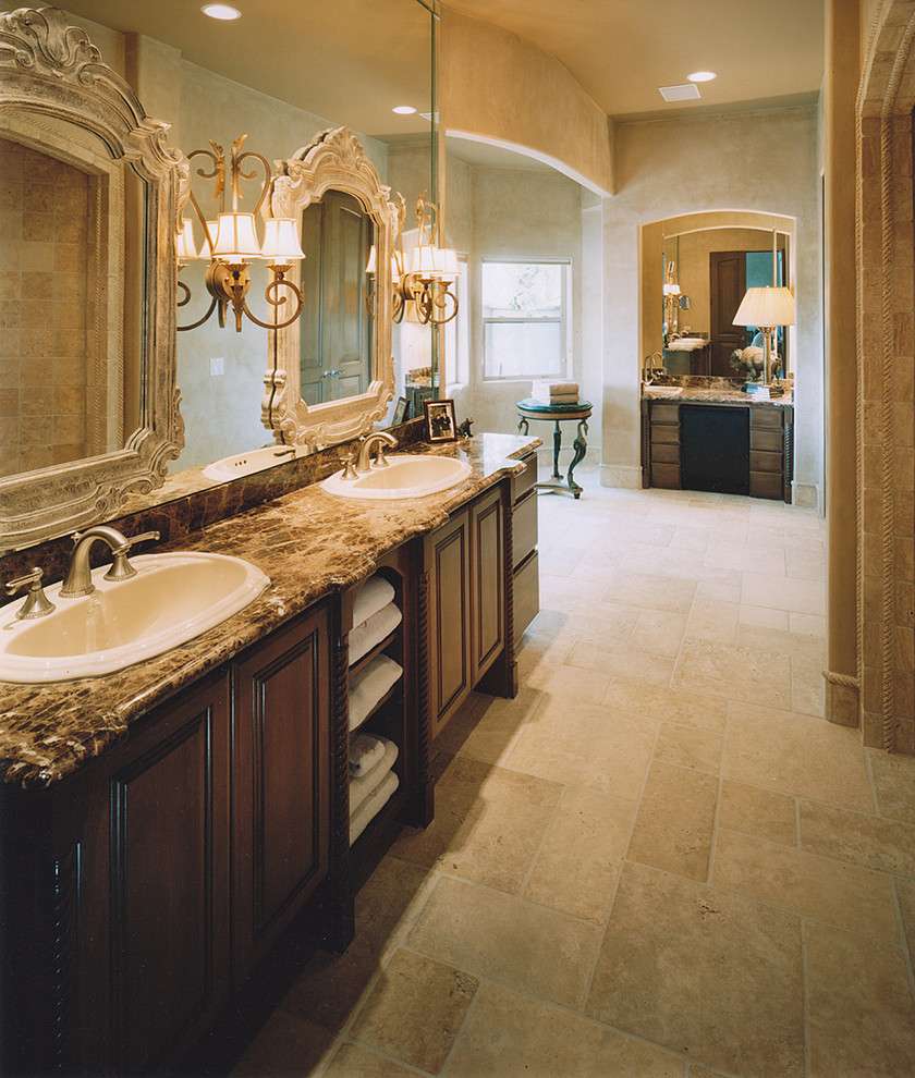 Traditional bathroom in Phoenix with a built-in sink, dark wood cabinets, beige tiles, raised-panel cabinets and beige floors.