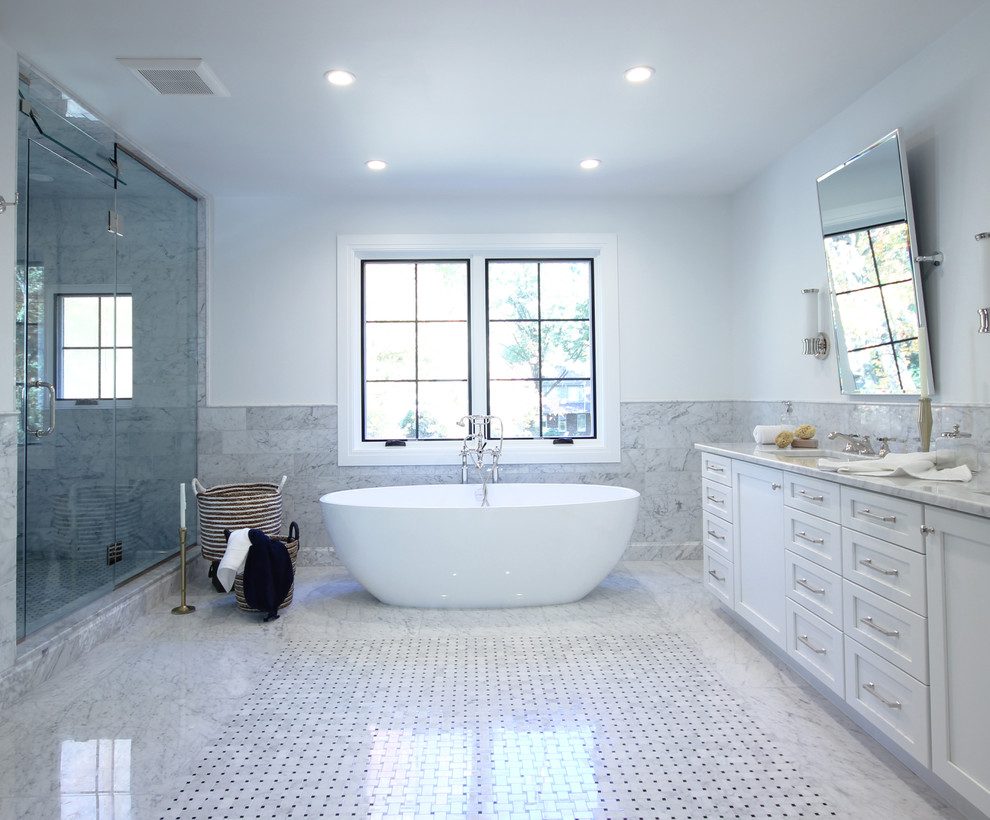 Example of a large transitional master gray tile, white tile and stone tile marble floor bathroom design in New York with recessed-panel cabinets, white cabinets, white walls, an undermount sink and marble countertops