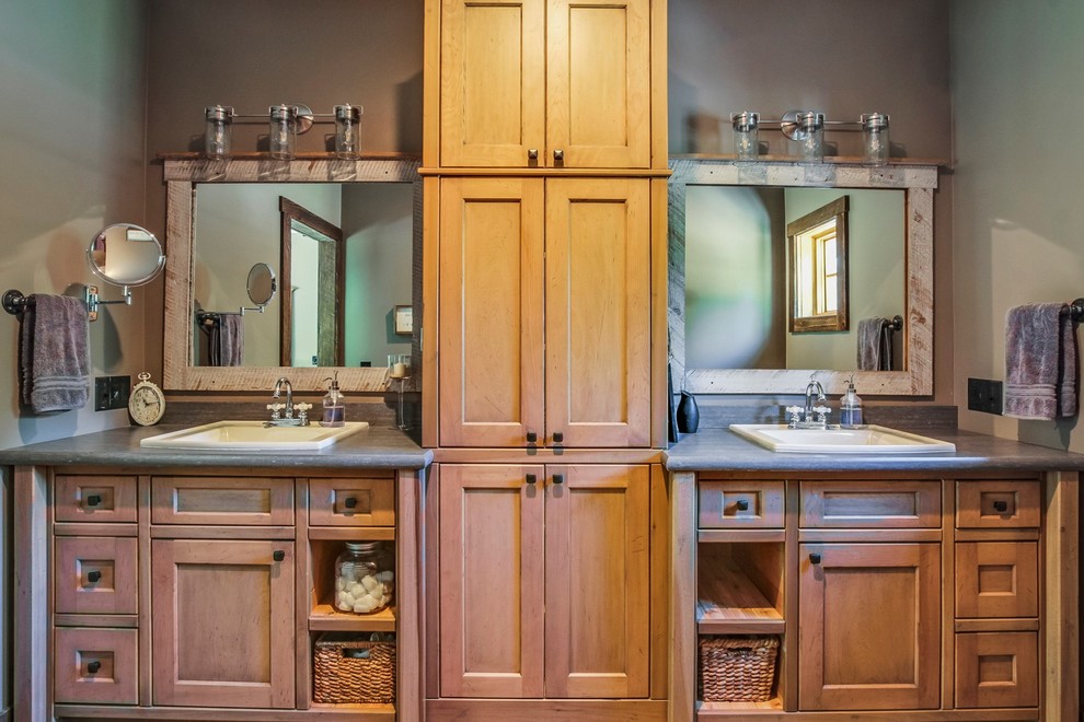 Example of a mid-sized mountain style master vinyl floor and brown floor alcove shower design in Grand Rapids with recessed-panel cabinets, distressed cabinets, a two-piece toilet, gray walls, a drop-in sink, wood countertops and a hinged shower door