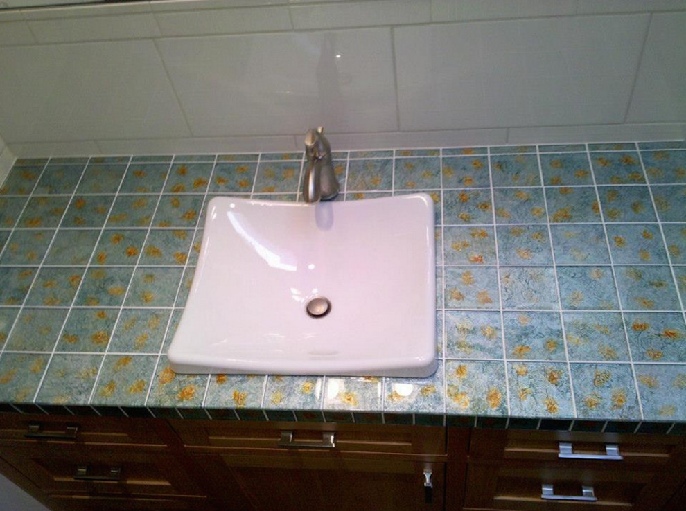 Immagine di una piccola stanza da bagno minimalista con lavabo da incasso, ante con riquadro incassato, ante marroni, top piastrellato, piastrelle blu e pareti bianche