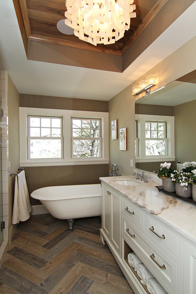 Transitional medium tone wood floor and brown floor freestanding bathtub photo in Minneapolis with an undermount sink, recessed-panel cabinets, white cabinets and brown walls