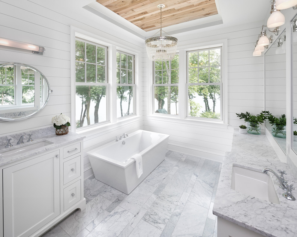 Beach style master gray floor and marble floor freestanding bathtub photo in Minneapolis with shaker cabinets, white cabinets, white walls, an undermount sink, gray countertops and marble countertops