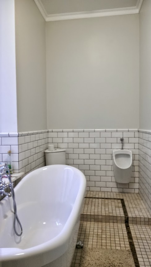 Aménagement d'une grande salle d'eau éclectique en bois foncé avec un placard sans porte, une baignoire indépendante, un combiné douche/baignoire, WC séparés, un carrelage blanc, des carreaux de béton, un mur gris, un sol en marbre, un plan vasque et un plan de toilette en marbre.