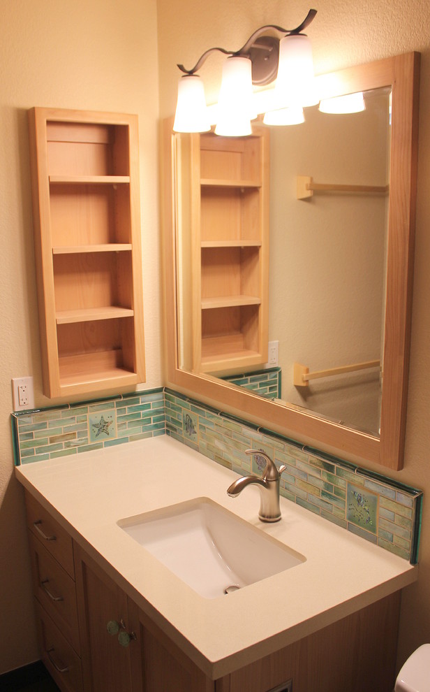 Diseño de cuarto de baño costero de tamaño medio con lavabo bajoencimera, armarios estilo shaker, puertas de armario de madera clara, encimera de cuarzo compacto, combinación de ducha y bañera, baldosas y/o azulejos de vidrio y paredes beige