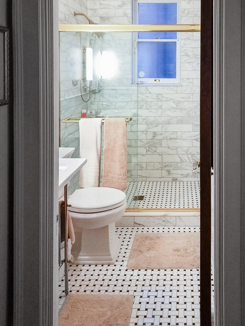 Mittelgroßes Stilmix Duschbad mit Duschnische, Wandtoilette mit Spülkasten, Marmorfliesen, grauer Wandfarbe, Linoleum, integriertem Waschbecken und Falttür-Duschabtrennung in Sonstige