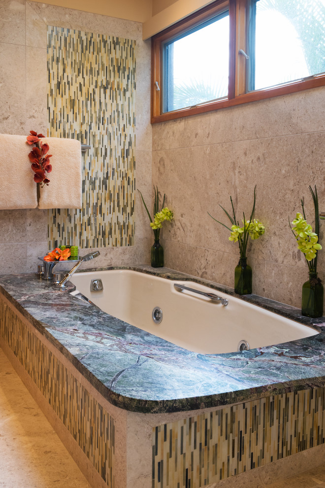 Cette image montre une salle de bain principale ethnique en bois brun avec un placard à porte plane, une baignoire encastrée, une douche à l'italienne, WC à poser, un carrelage multicolore, des carreaux en allumettes, un mur beige, un sol en calcaire, un lavabo encastré et un plan de toilette en marbre.