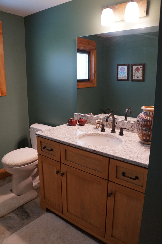 Cette image montre une salle de bain craftsman en bois clair avec un placard à porte shaker, un plan de toilette en quartz modifié, une baignoire sur pieds, un carrelage beige, des carreaux de céramique, un mur bleu et un sol en carrelage de céramique.
