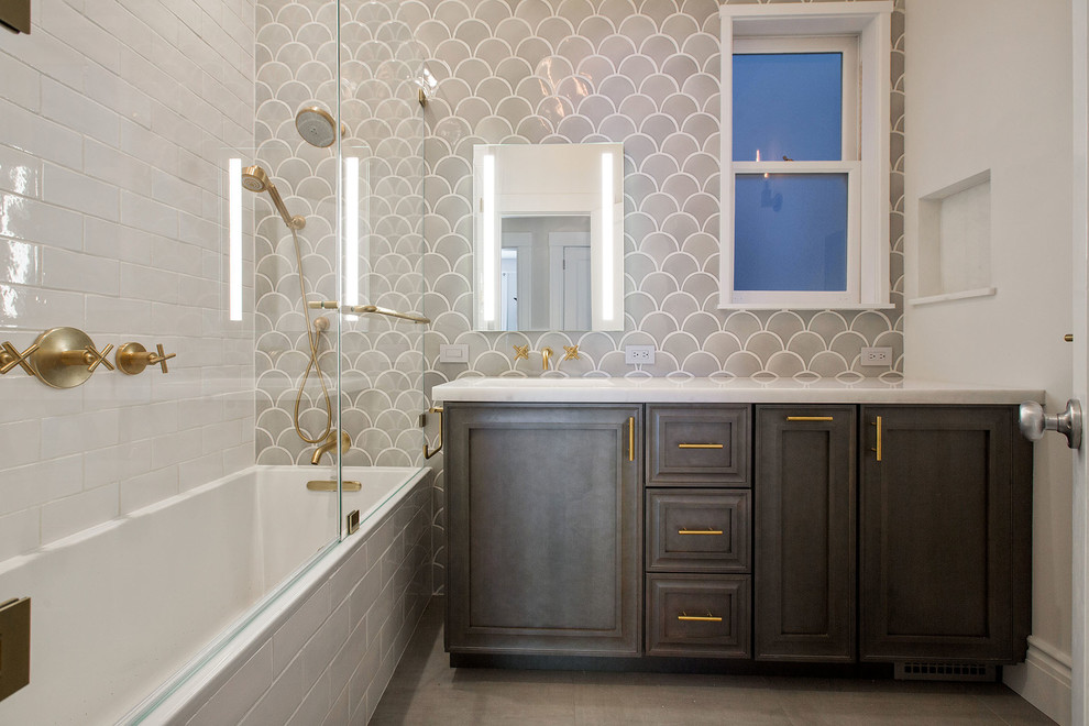 This is an example of a medium sized contemporary ensuite bathroom in San Francisco with freestanding cabinets, grey cabinets, an alcove bath, a shower/bath combination, a one-piece toilet, grey tiles, porcelain tiles, white walls, porcelain flooring, a submerged sink, marble worktops, grey floors and a hinged door.