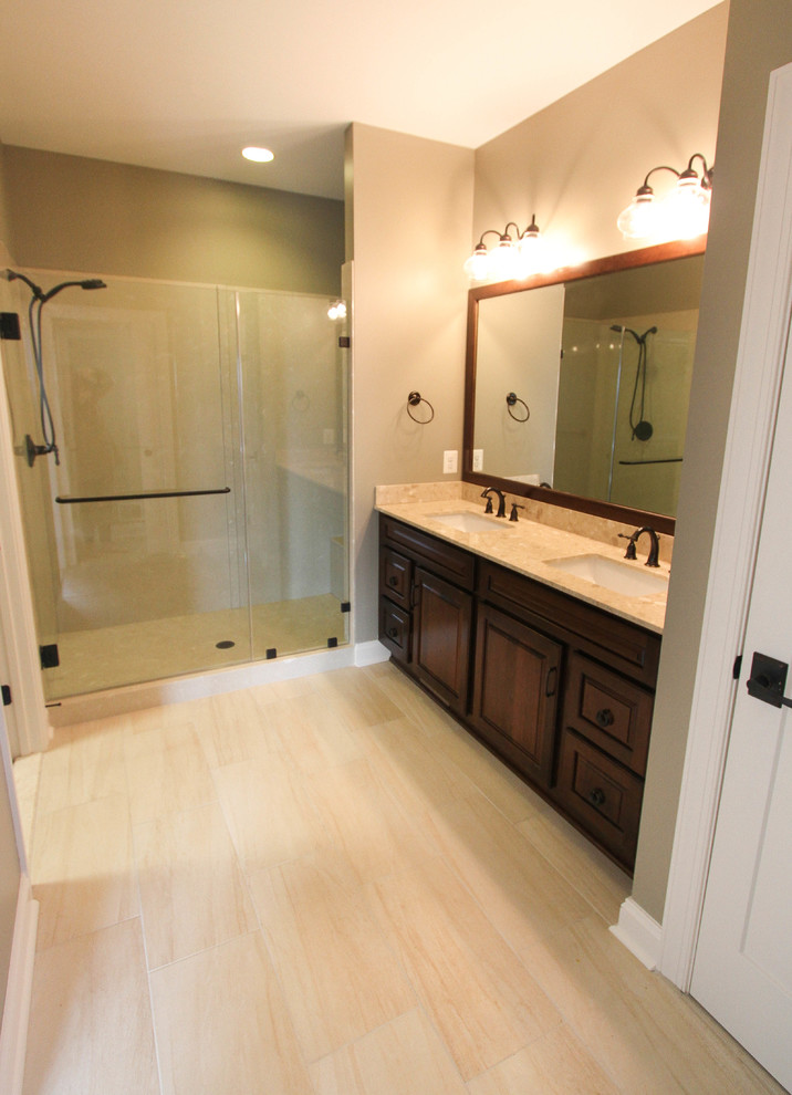Foto di una stanza da bagno padronale american style di medie dimensioni con ante con bugna sagomata, ante in legno bruno, piastrelle beige, piastrelle in ceramica e top in marmo