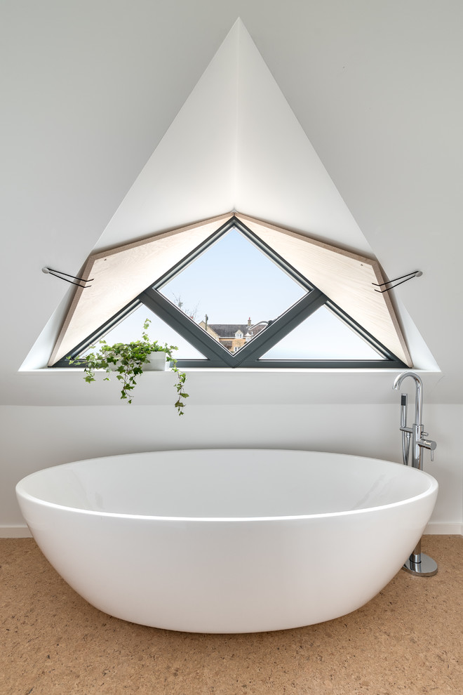 Idée de décoration pour une salle de bain design de taille moyenne avec une baignoire indépendante, un mur blanc, un sol en liège et un sol marron.