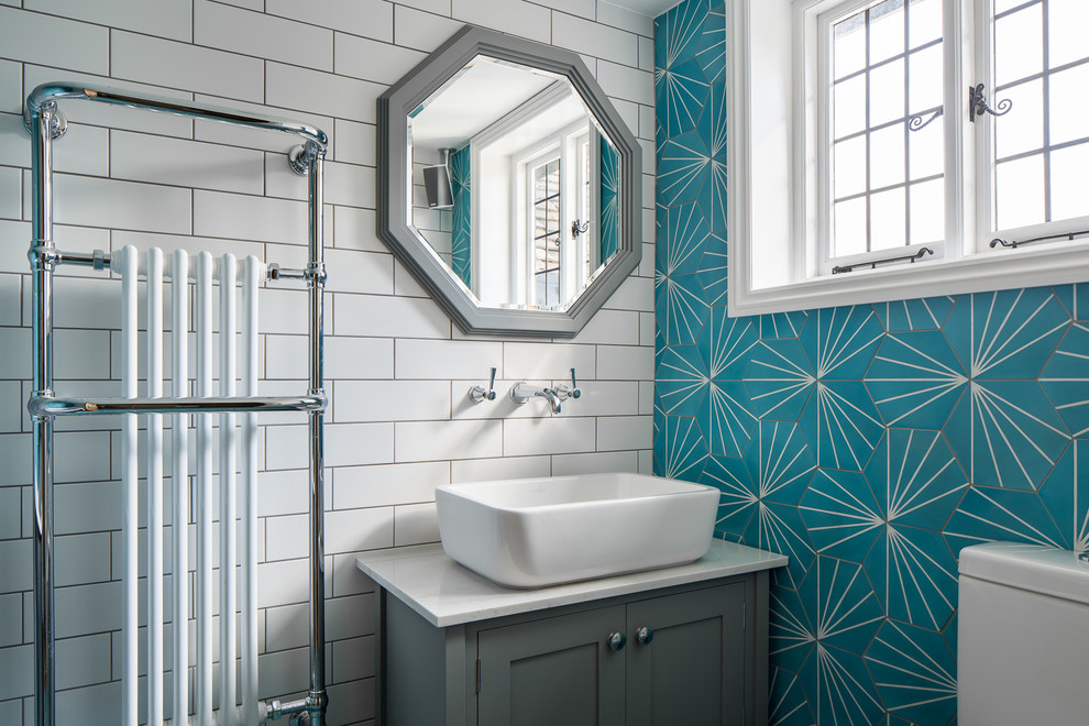Diseño de cuarto de baño tradicional renovado con armarios estilo shaker, puertas de armario grises, baldosas y/o azulejos azules, lavabo sobreencimera y encimeras blancas