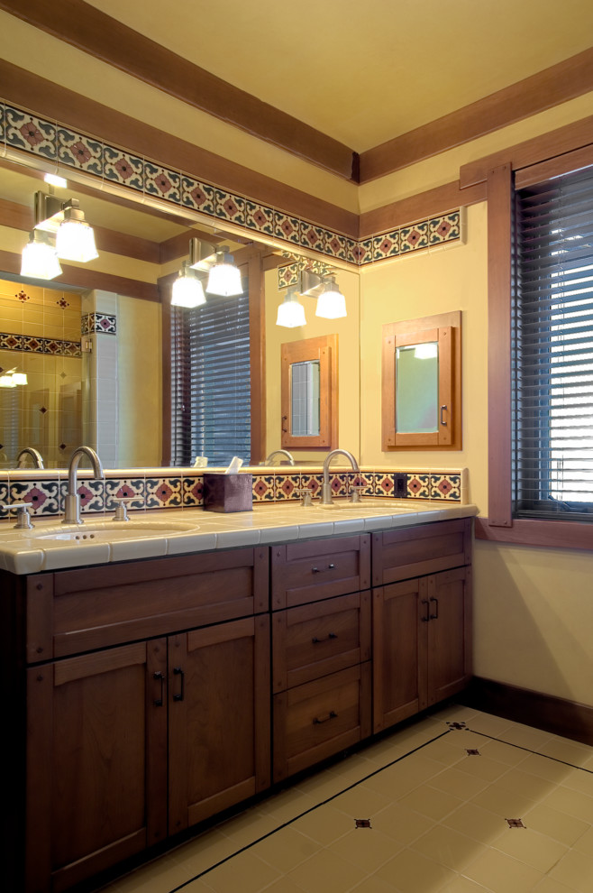 Réalisation d'une salle de bain principale craftsman en bois brun de taille moyenne avec un placard à porte shaker, un carrelage multicolore, des carreaux de céramique, un mur beige, un sol en carrelage de céramique, un lavabo encastré, un plan de toilette en carrelage et un sol beige.