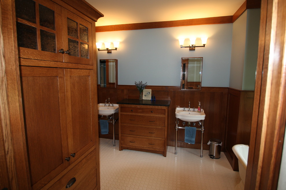На фото: главная ванная комната среднего размера в классическом стиле с фасадами в стиле шейкер, фасадами цвета дерева среднего тона, ванной на ножках, белой плиткой, керамогранитной плиткой, синими стенами, полом из керамогранита и подвесной раковиной с