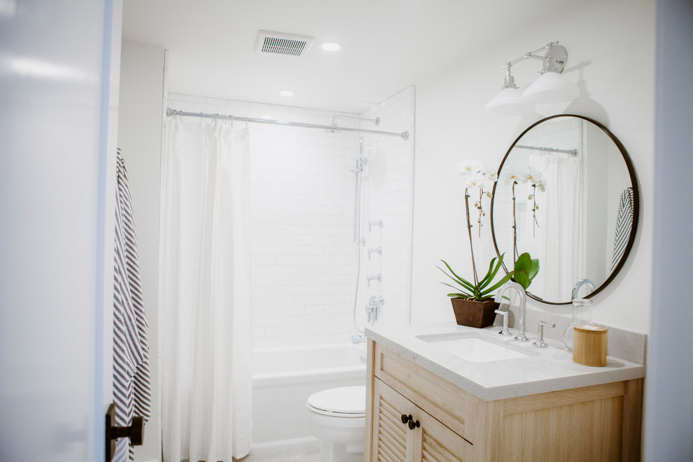 Mid-sized beach style white tile and porcelain tile ceramic tile and gray floor bathroom photo in San Diego with louvered cabinets, light wood cabinets, a one-piece toilet, white walls, an undermount sink and quartz countertops