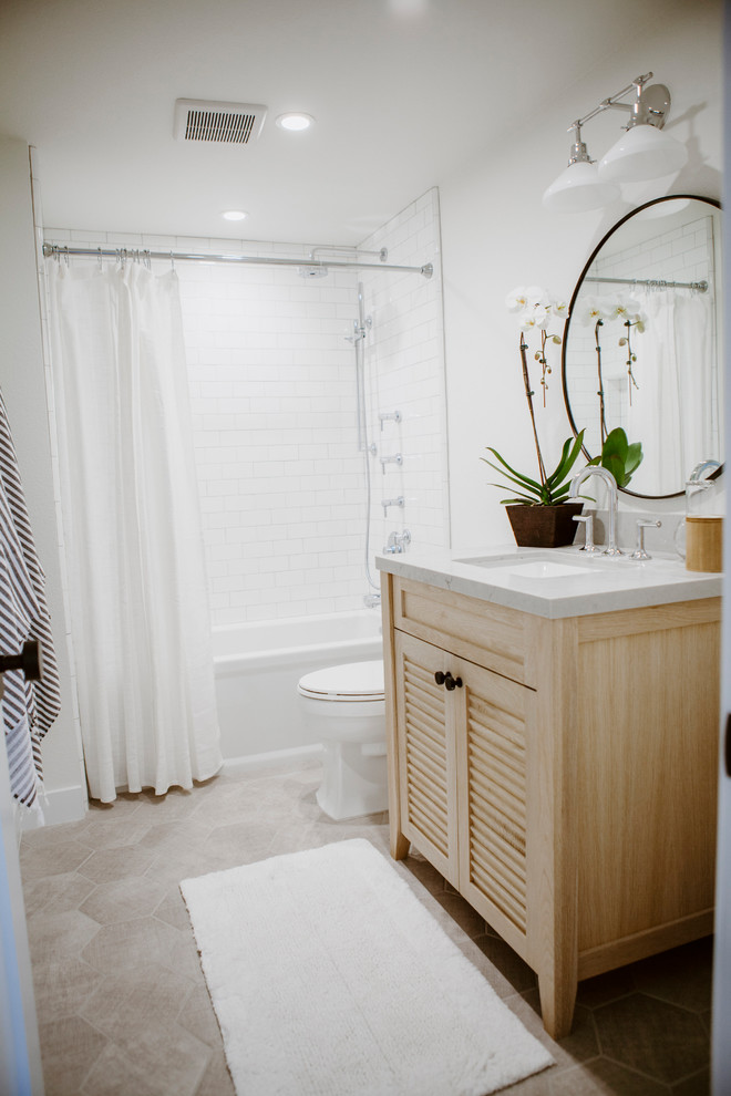 Idéer för mellanstora maritima badrum, med luckor med lamellpanel, skåp i ljust trä, ett badkar i en alkov, en dusch/badkar-kombination, en toalettstol med hel cisternkåpa, vit kakel, porslinskakel, vita väggar, klinkergolv i keramik, ett undermonterad handfat, bänkskiva i kvarts, grått golv och dusch med duschdraperi