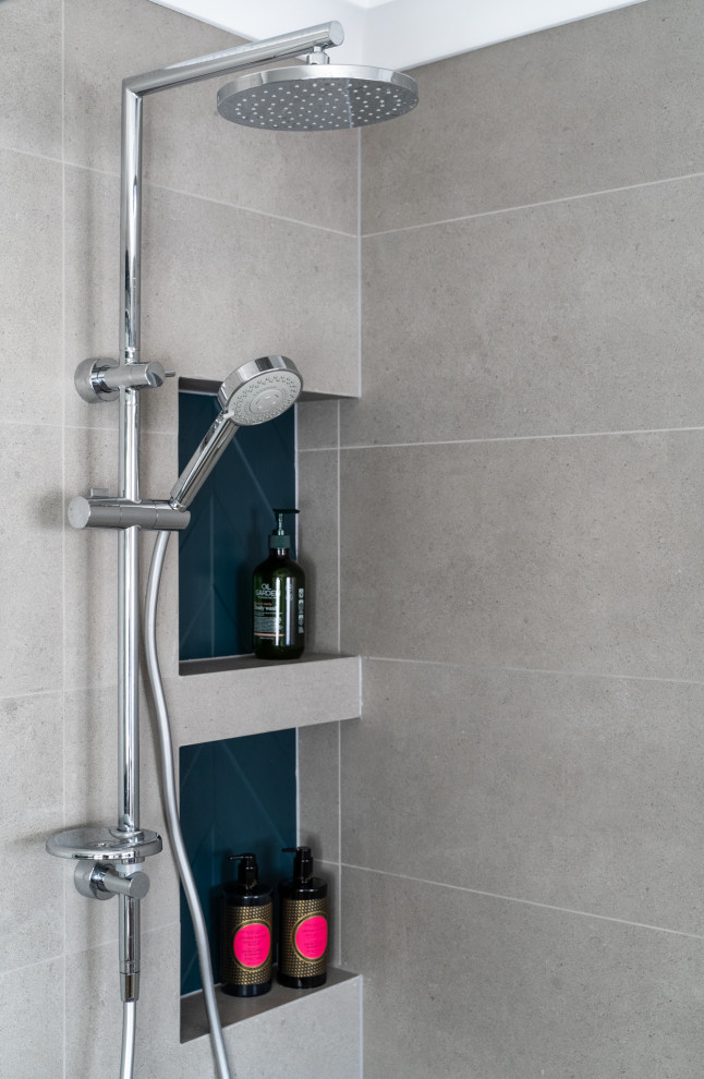 This is an example of a medium sized contemporary ensuite bathroom in Perth with freestanding cabinets, light wood cabinets, a one-piece toilet, multi-coloured tiles, ceramic tiles, multi-coloured walls, ceramic flooring, a vessel sink, solid surface worktops, grey floors, a hinged door, white worktops, a single sink and a floating vanity unit.