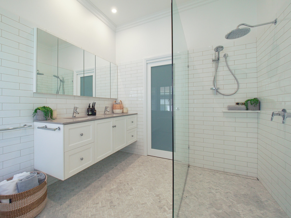 Design ideas for a large contemporary ensuite bathroom with shaker cabinets, white cabinets, a freestanding bath, a walk-in shower, a one-piece toilet, white tiles, porcelain tiles, white walls, marble flooring, a submerged sink, engineered stone worktops, grey floors and an open shower.