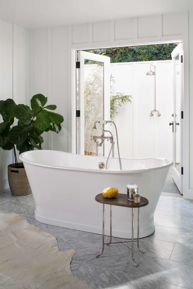 This is an example of a large rural ensuite bathroom in Los Angeles with beaded cabinets, white cabinets, a freestanding bath, an alcove shower, a two-piece toilet, white tiles, marble tiles, white walls, marble flooring, a built-in sink, marble worktops, grey floors, a hinged door and white worktops.